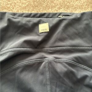 Navy blue Vuori performance stride leggings with side pockets size M